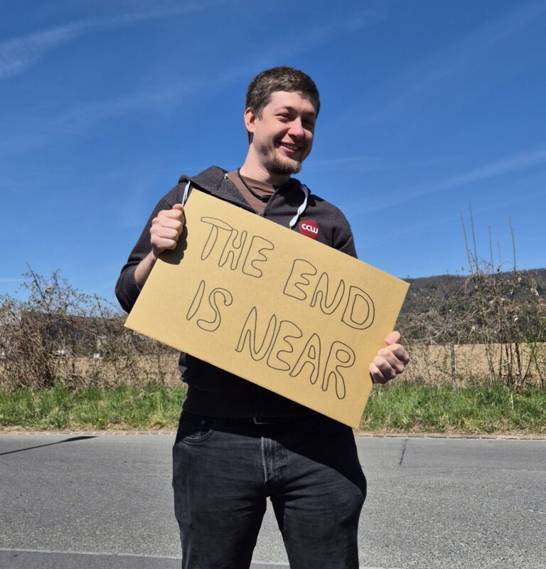 Eine Person hält ein Kartonschild mit der Aufschrift "The end is near"